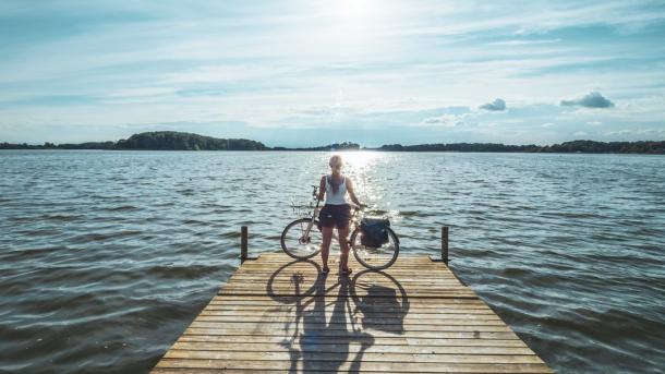 Cyclist standing at Soendersoe lake in Maribo, Lolland-Falster