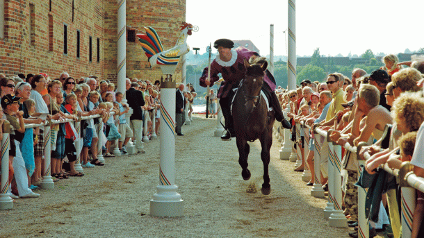 Ein Bild von einer Ringreitervorstellung vor dem Schloss Sønderborg mit einem Reiter im historischem Kostüm