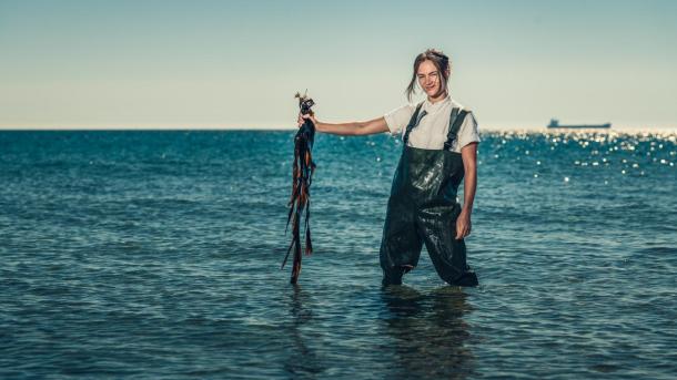 Chef Mathilde from restaurant Blink foraging seaweed by the beach in Skagen, North Jutland