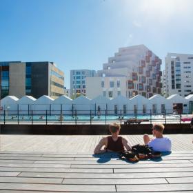 People enjoying the sun beside the harbour bath in Odense, Denmark