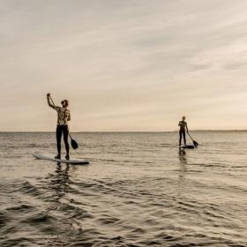 Two people go paddleboarding on a calm sea at Klitmøller, Thy National Park